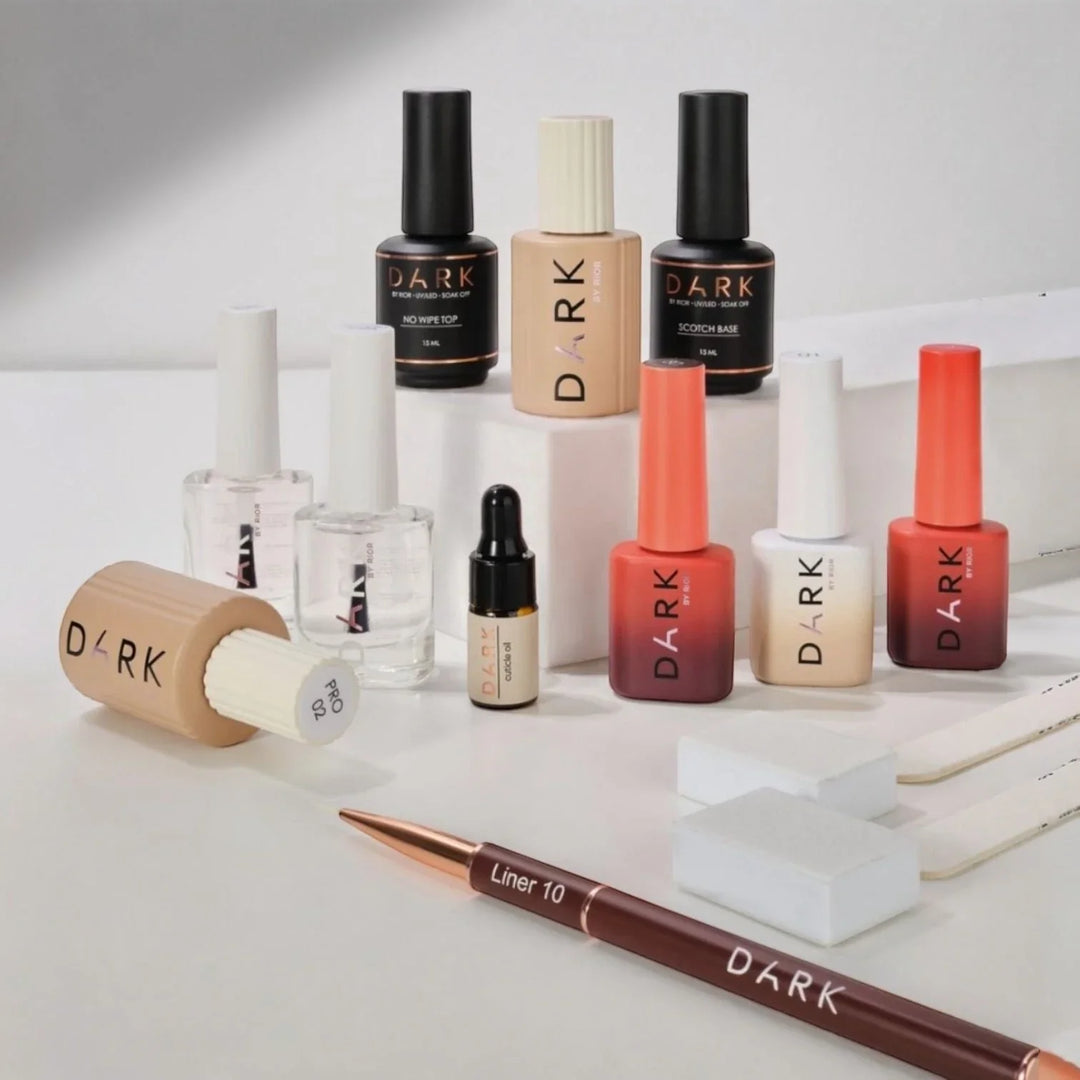 Lahvičky v černé, bílé, rudé a bežové barvě, obsahující produkty značky DARK, poskládané na bílem stole.