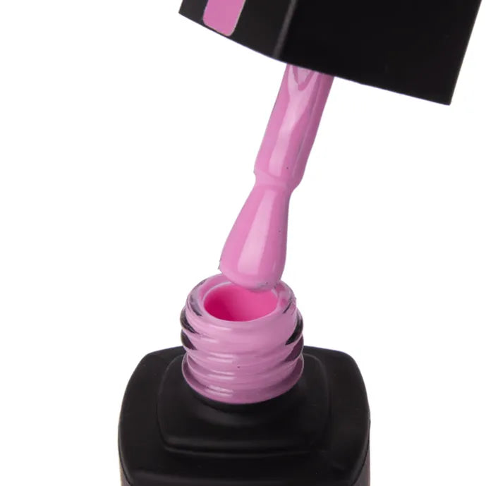 Close-up of a pink nail polish bottle with a brush loaded with pink polish.