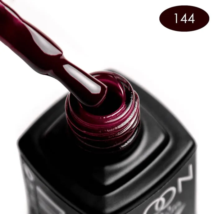 Close-up of a bottle of dark red nail polish with a visible brand name.