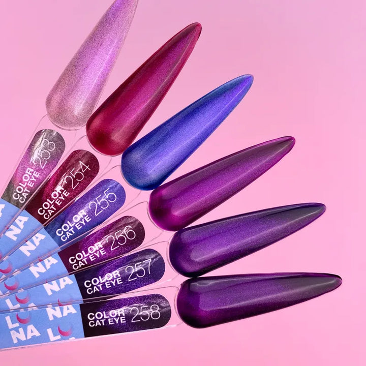 Set of colorful nail polish samples with a gradient effect on a pink background