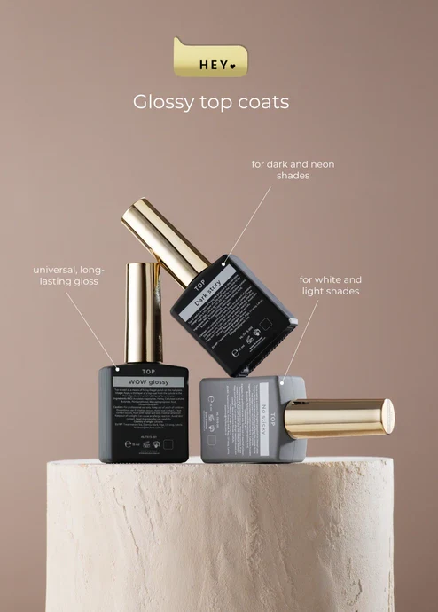 Nail polish bottles with glossy top coats on a beige background