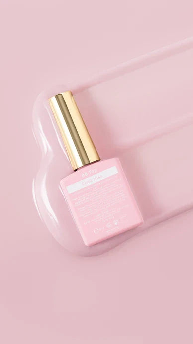 Pink nail polish bottle with gold cap on a pink background