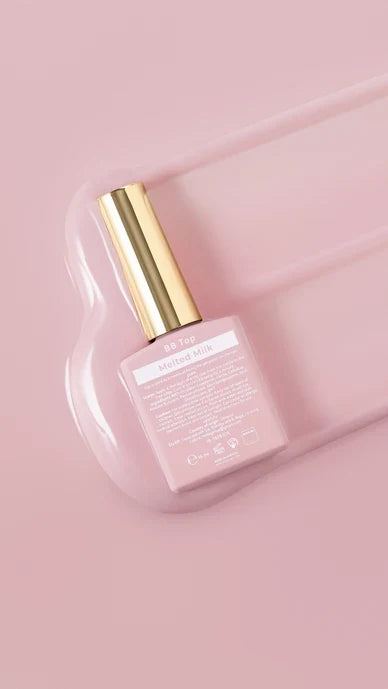 Pink nail polish bottle with gold cap on a pink background