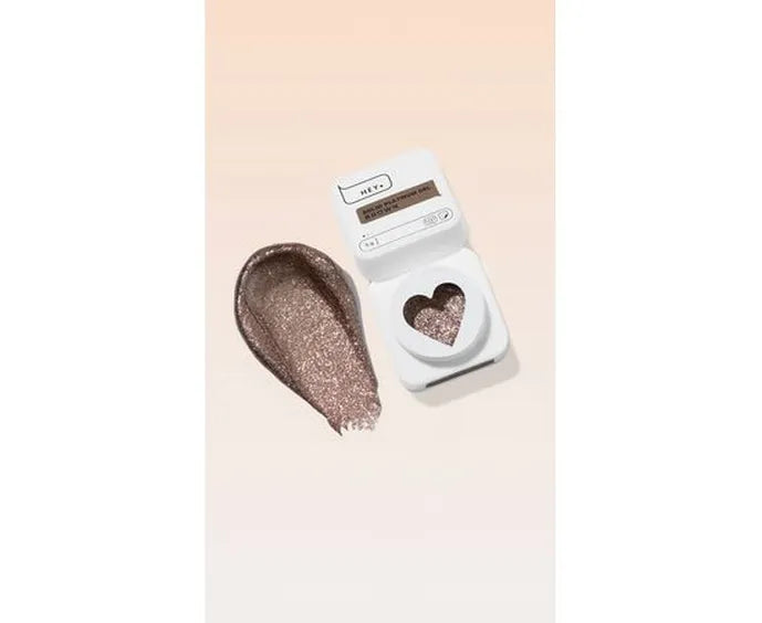 Heart-shaped glittery object next to a white device on a light pink background. Brand: HEYLOVE