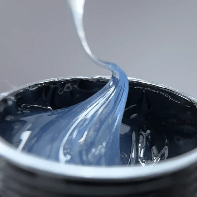 Close-up of blue liquid being poured into a container with a blurred background