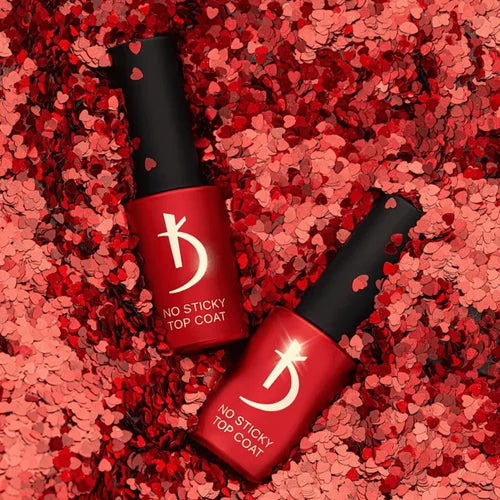 Two red nail polish bottles with black caps on a red textured background
